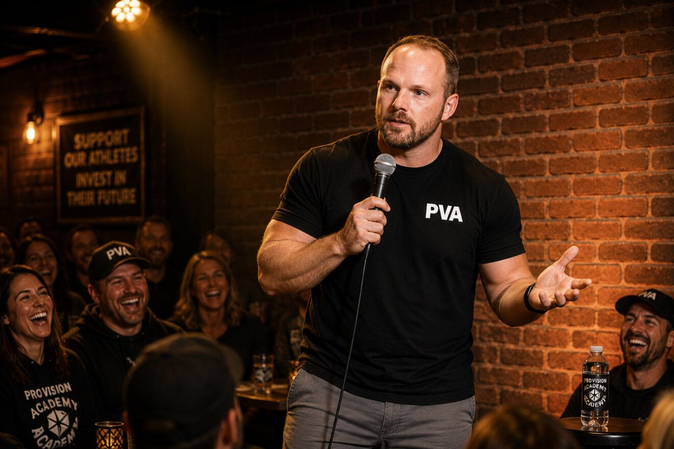 A coach holding a microphone on stage at Jokes for Jerseys